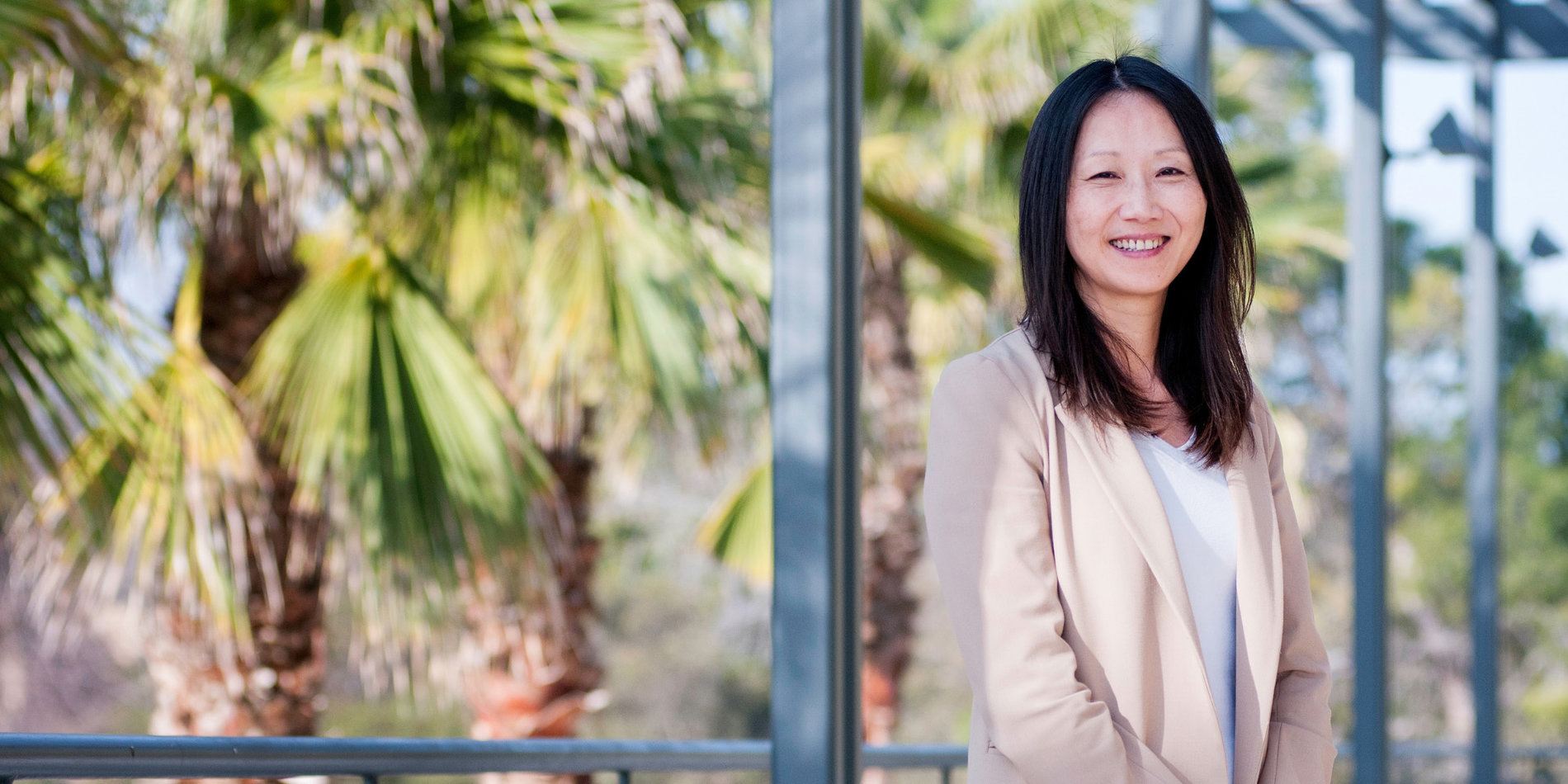 Zhenan Bao posing with palm trees in the background