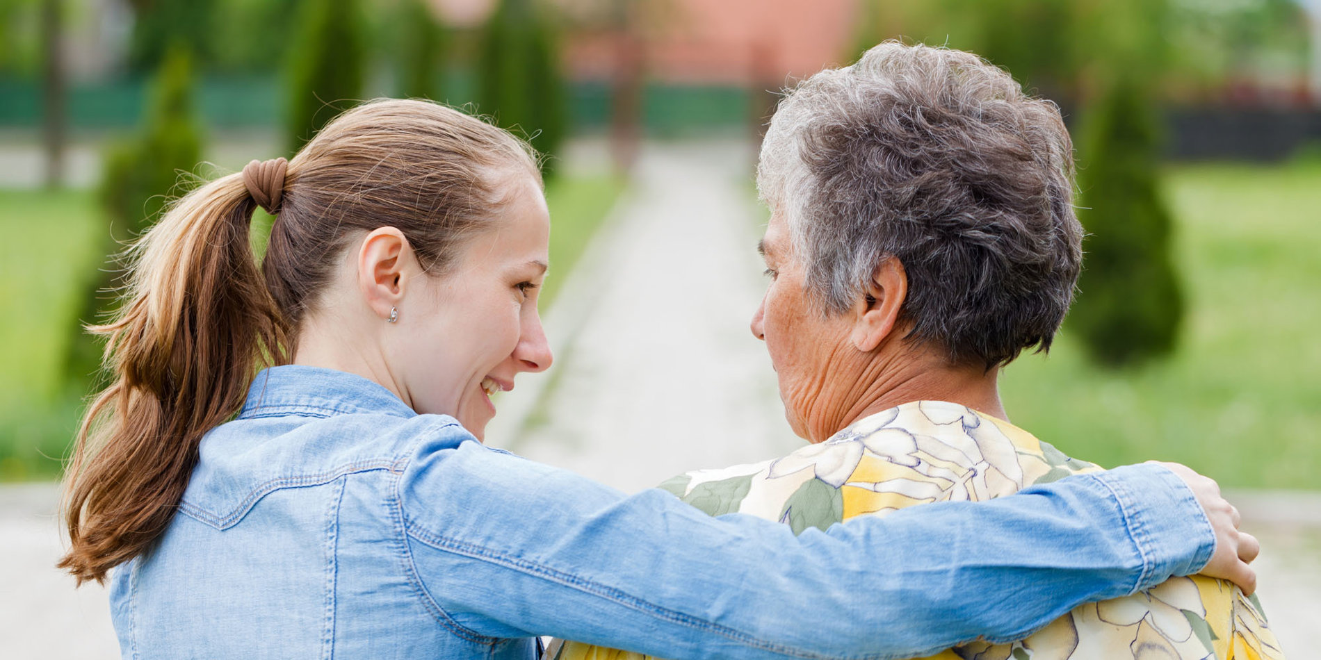 Young woman with her arm around an elderly woman