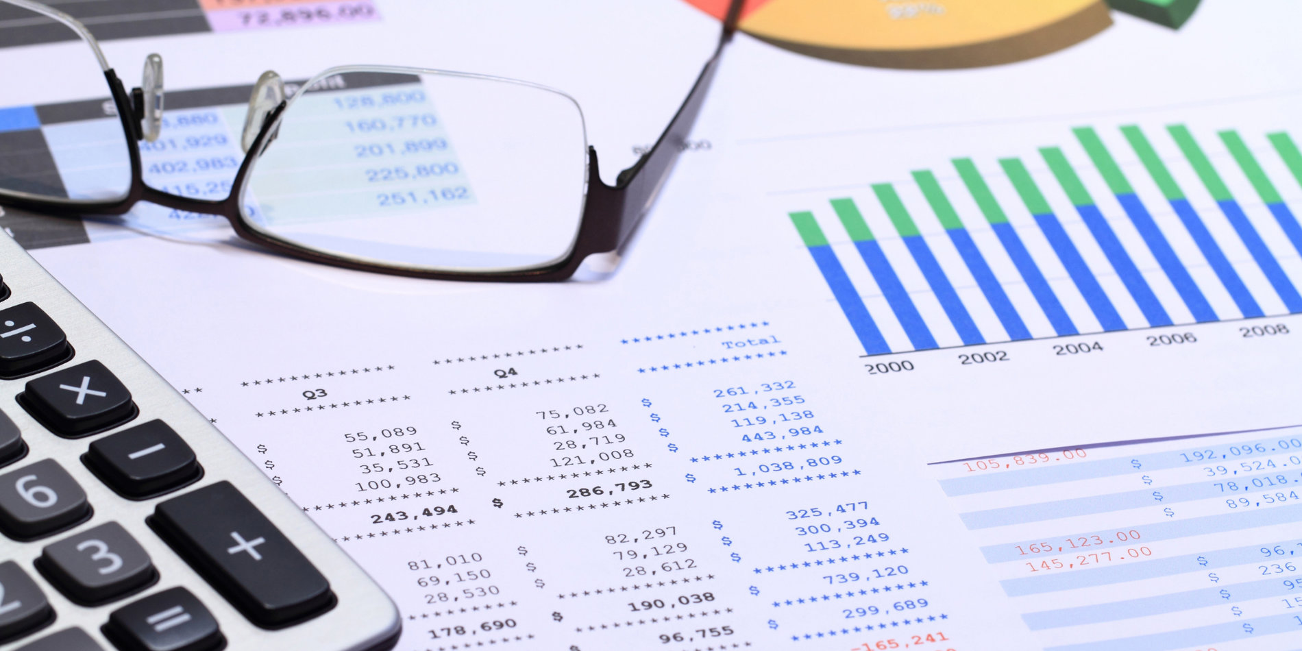 papers with charts and graphs covering a desk
