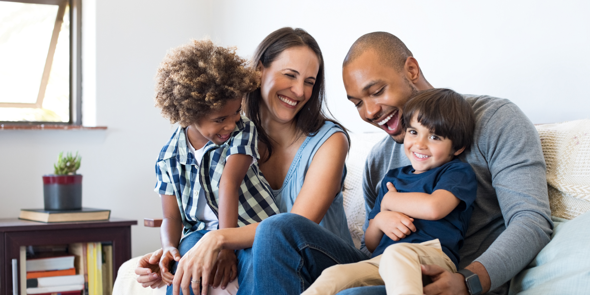 Couple holding their kids on their laps and laughing together