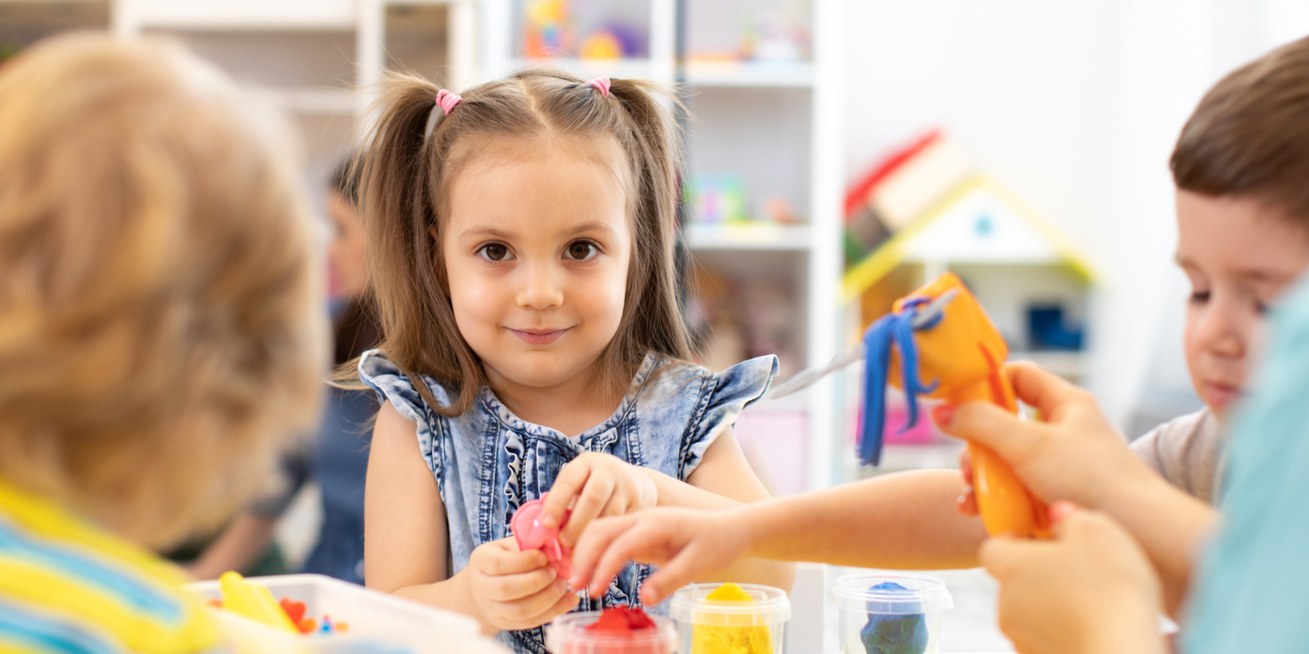 Group of kids playing with modeling clay in nursery