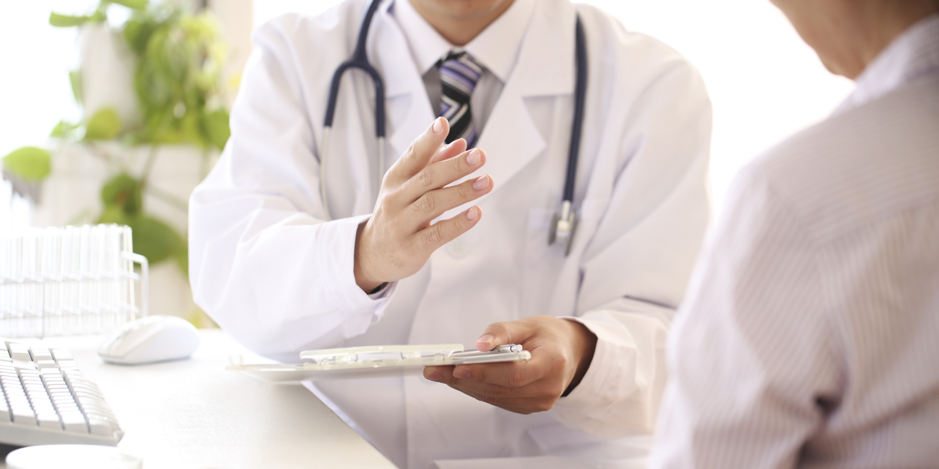 Doctor talking to patient at computer desk
