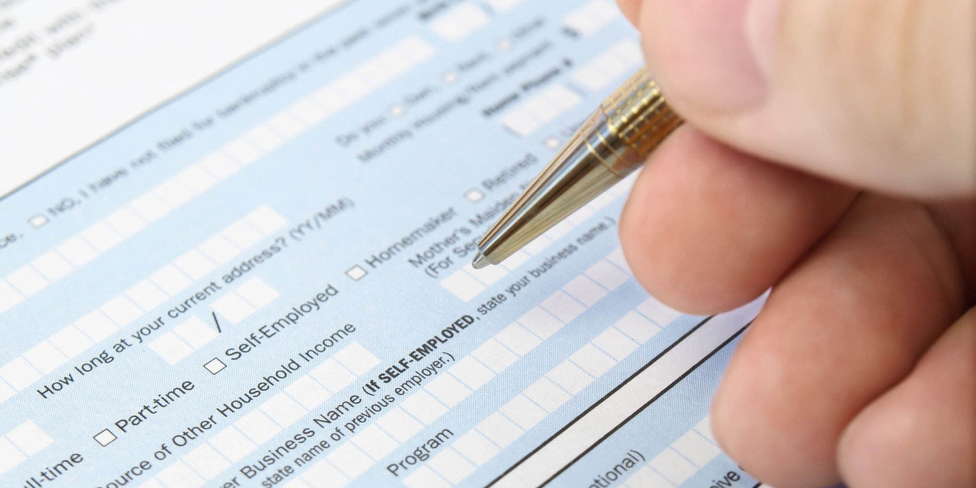 Close up of hand filling out application form