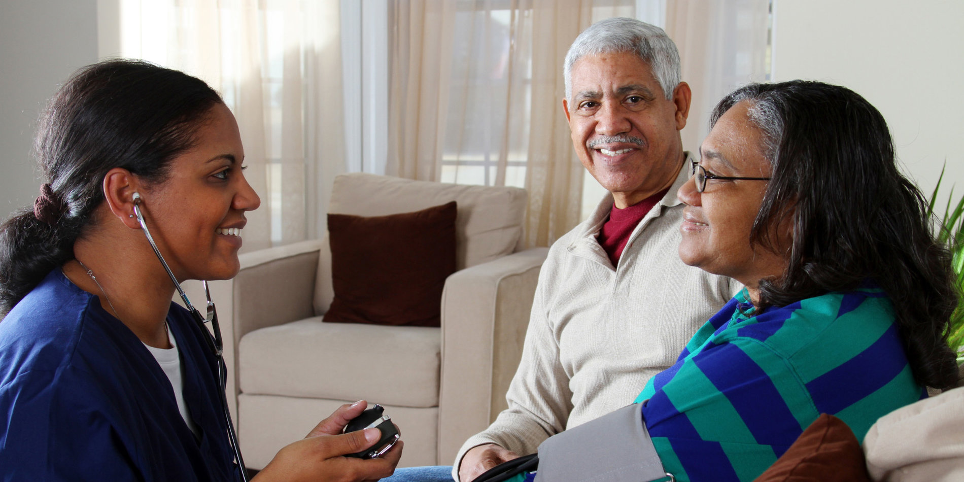 Senior couple getting blood pressure taken at home