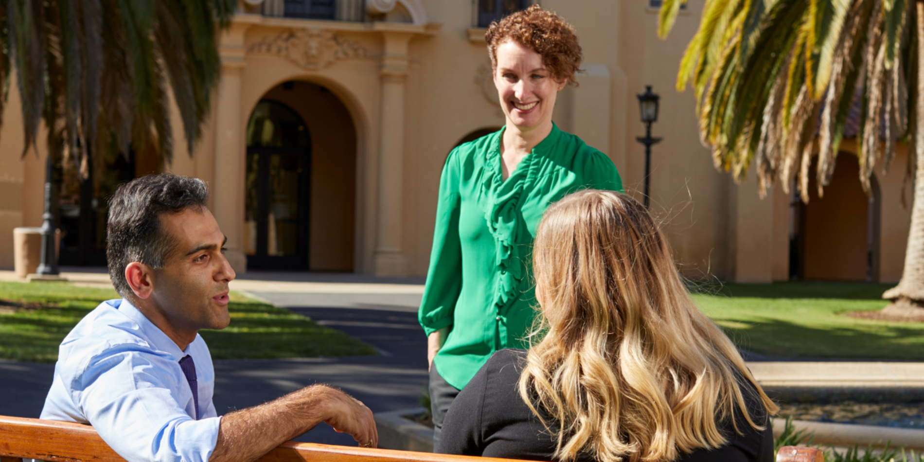 Three staff members meet outside of Old Union